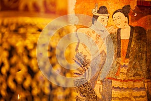 Ancient murals painting of man whispering to woman, famous mural painting at Wat Phumin, a famous buddhist temple in Nan Province