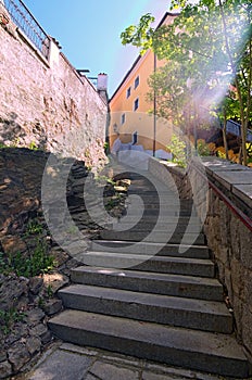 Ancient narrow stairs in Cesky Krumlov at sunny day.