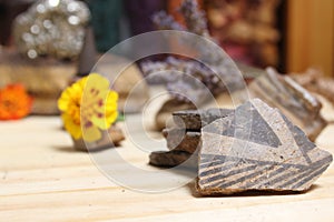 Ancient Native American Pottery Pieces With Crystals and Flowers on Meditation Table