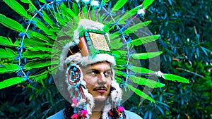 Ancient Native Mesoamerican priest wearing a headdress in the jungle.