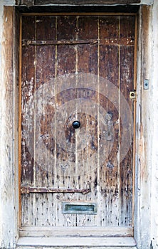 An ancient oak wood door with ornate metal handle