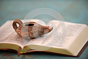 Ancient Oil Lamp on Open Bible photo