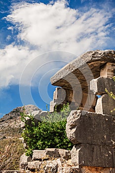 Ancient old ruined tombs on sunny day against cloudy sky