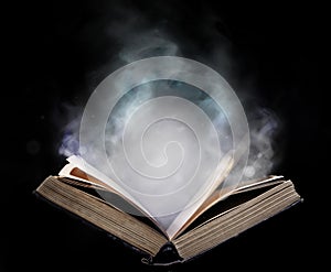 Ancient open book in the magical smoke