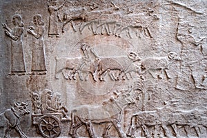 Ancient persian bas-relief depicting people and livestock