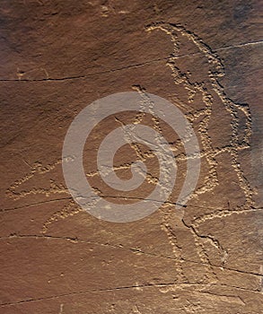 An ancient petroglyph of  hunter with bow and  silhouette of  running animal