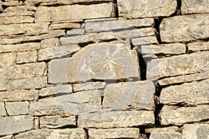 Ancient petroglyphs on the stone walls of an old house