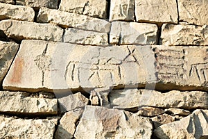 Ancient petroglyphs on the stone walls of an old house