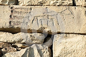 Ancient petroglyphs on the stone walls of an old house