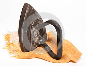 The ancient pig-iron iron on an orange napkin