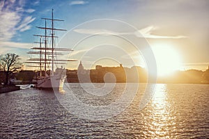 Ancient pirate ship sailing on the ocean at sunset. In full sail. Classic sailing ship with sails lowered at sunset.