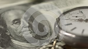 Ancient pocket watch lying on dollar bill, time is money, banking and finance