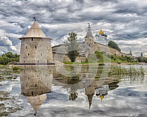 Ancient the Pskov Kremlin in summer day with reflection in the Velikay river.