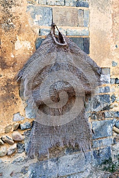 Ancient rainsuit hanging outside a rural home in the Daxu