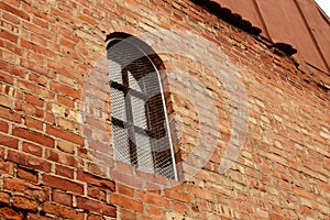 Ancient red brick wall with arched window
