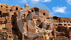 Ancient red clay village Kharanagh against blue sky. Persia. Iran. Sight of Yazd. photo