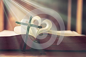 Ancient religious book and wooden cross on the background of a wooden photo