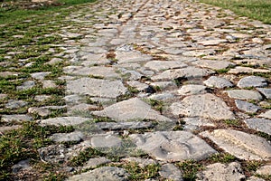 Ancient road paved with cobblestone. Closeup.