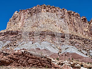 Ancient rock formations tower above the abandoned Oyler Uranium Mine entrance at Capitol Reef National Park, Utah, USA