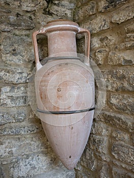 ancient Roman amphora hanging on a stone wall