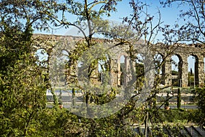 Ancient roman aqueduct ouside Rome, surrounded by trees