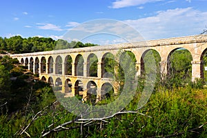 Ancient roman aqueduct in summer forest. Tarragona,