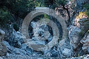 Ancient Roman bridge over a shady gorge in the Kesme Bogazi canyon, Turkey