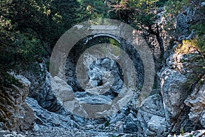 Ancient Roman bridge over a shady gorge in the Kesme Bogazi canyon, Turkey