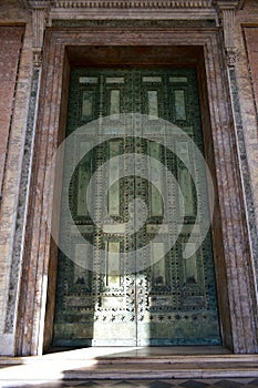 Ancient roman bronze door from Roman Senate still in use. Archbasilica of Saint John Lateran facade. Rome, Italy.