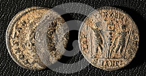 Ancient Roman coin of Emperor Constantius II, top view of vintage metal money isolated on black background. Theme of old grungy