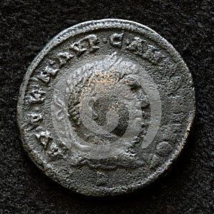 Ancient Roman coin of Emperor Elagabalus, top view of vintage metal money isolated on black background. Concept of old bronze