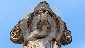 Ancient Roman column capital (head) with blue sky in the background in Pompeii. Pompei, Campania, Italy, July 2020.