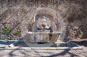 Ancient roman fountain named `Mascherone di Santa Sabina` on the Aventine Hill in Rome, Italy.