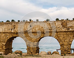 Ancient Roman ruins of aqueduct in Ceasarea Israel historical monument. photo