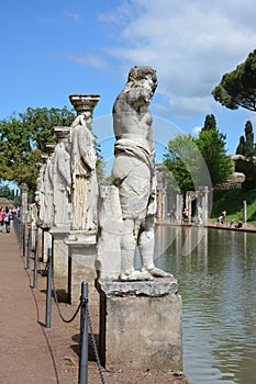 Ancient roman statues at the edge of a pond in Tivoli, Italy