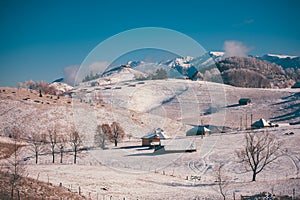 Ancient romanian houses on the frozen hills in the middle of winter