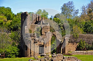 Ancient ruins on the Appian Way, Rome. Red brick ruins, green woodland and blue sky background