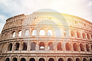 Ancient ruins Colosseum Rome, Italy, background blue sky with clouds, sunset light