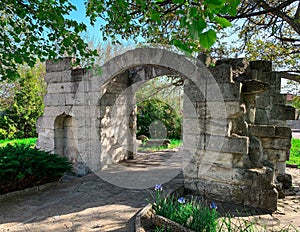 Ancient ruins of stone entrance gate in the garden photo