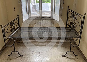 Ancient rusty iron bed in an abandoned and ruined room