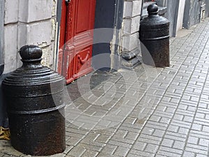 Ancient rusty iron guns cannons columns in the ground near building entrance