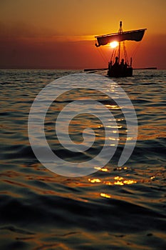 Antico barca a vela sul tramonto 