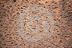 Ancient sandstone masonry, weathered rough surface closeup photo. Porous texture of natural stone