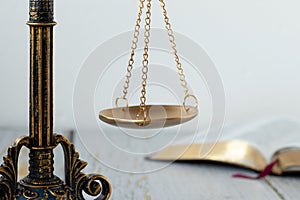 Ancient scales of justice and open holy bible book with white background, close-up