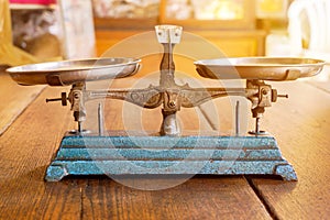 Ancient scales with the weight balance put on wooden table in a Chinese herbs shop and sun flare background