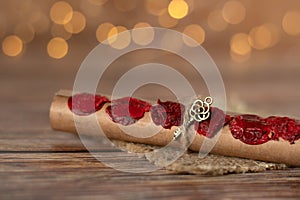 Ancient scroll with seven seals and golden key isolated on wooden table with blurred bokeh background, a close-up