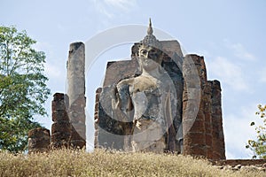 Ancient sculpture of a Buddha on a hill. Sukhothai, Thailand