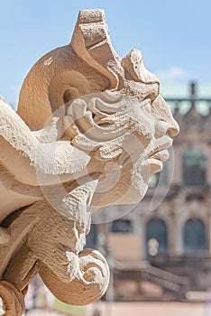 Ancient sculpture of funny, tricky and joyful dickens at Zwinger palace, gardens, fountains in historical downtown of Dresden,
