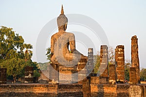 Ancient sculpture of a seated Buddha on the ruins of the temple Wat Chana Songkhram. The view from the back. Sukhothai, Thailand