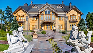 Ancient sculptures at the entrance of a huge wooden building against the blue sky